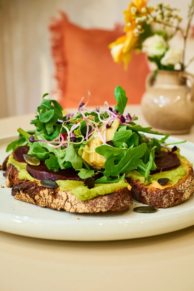 Green & Fresh mit orangem Kissen und Blumen